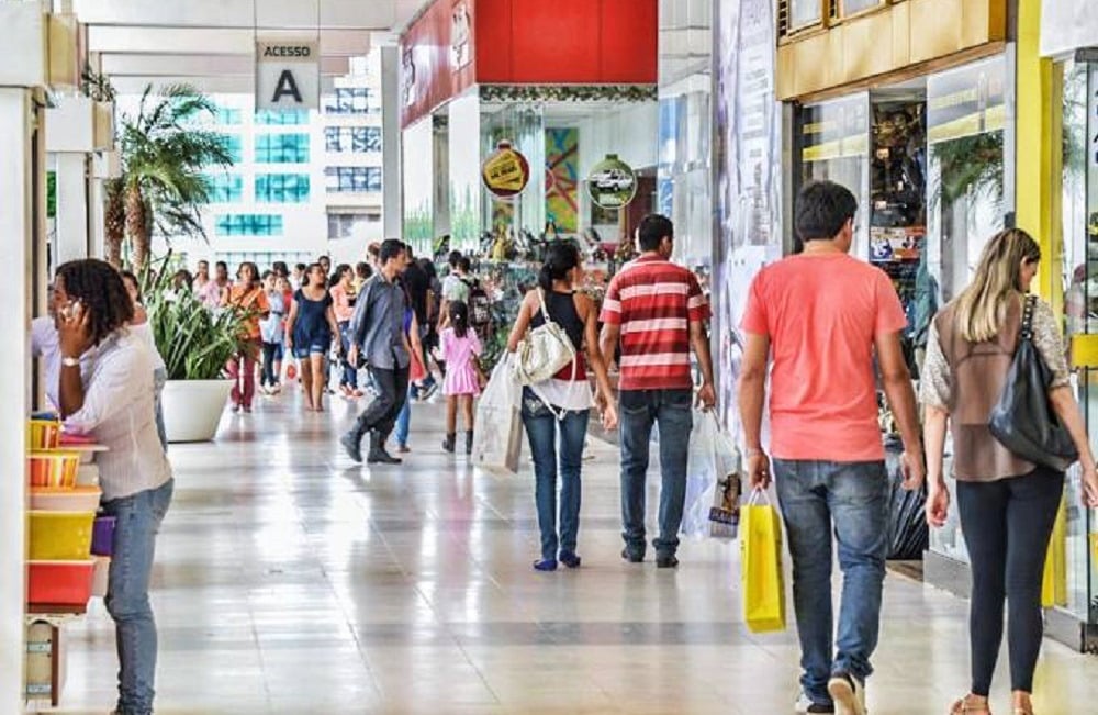 imagem de pessoas andando em shopping fazendo compras.