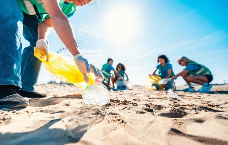 a person holding a plastic bag in the sand