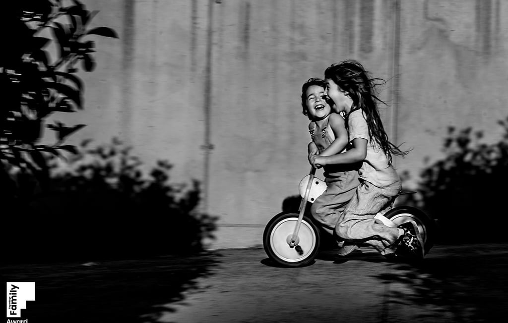 a little girl riding a tricycle in a black and white photo