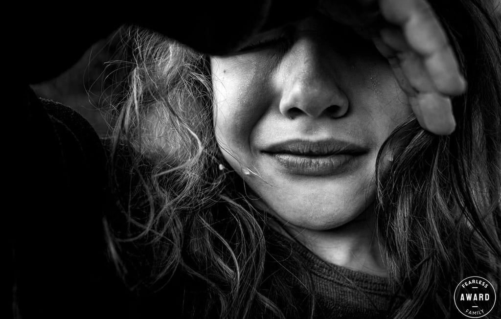a girl with long hair and a tear in her face