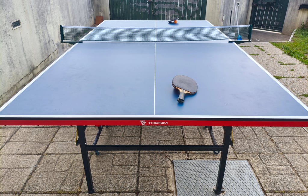 Mesa de ténis de mesa TOPGIM Training com raquete e rede — vista frontal em exterior