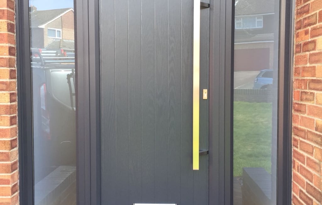 modern grey composite door with no glass.  Ral 7016 coloured frame.  2 side panels 