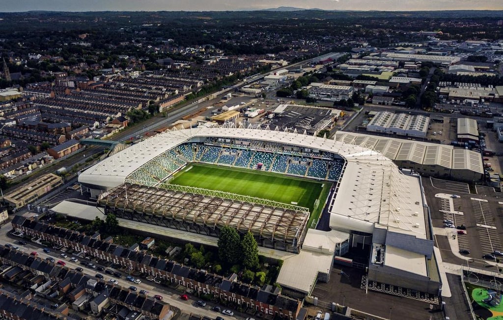 Luftaufnahme des Windsor Park in Belfast mit Blick auf das Spielfeld, die Tribünen und die umliegenden Wohngebiete.