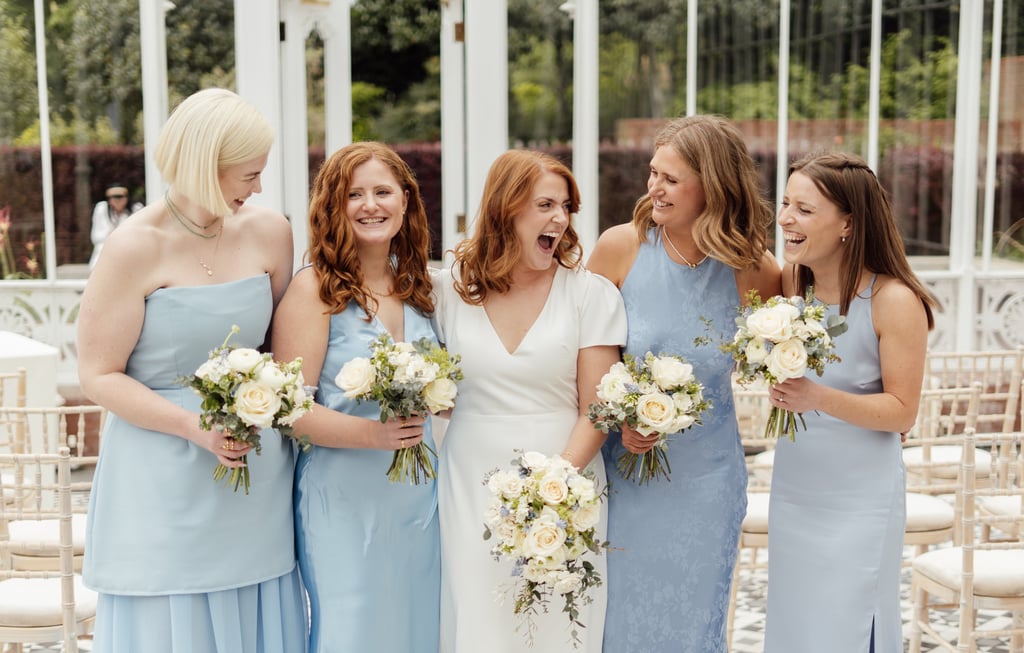 bride with her bridesmaids laughing and looking at each other