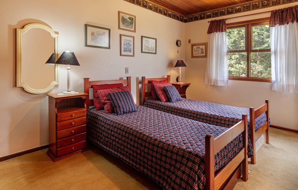 Quarto com duas camas com lençóis com estampa xadrez