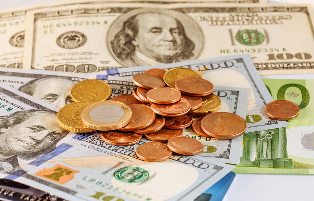 US dollars and euro coins on a table with money tips for traveling to the Dominican Republic
