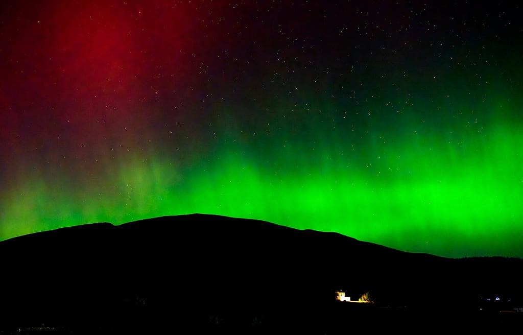 Aurora Borealis Northern Lights bright green and red auroras in the Scottish Highlands