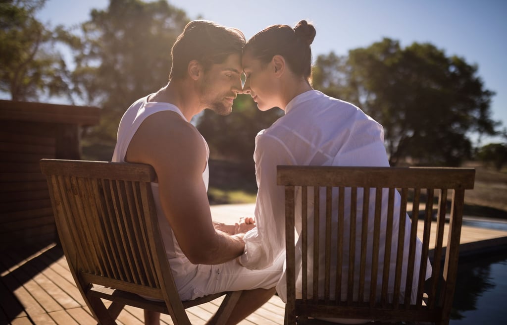 a man and woman sitting on a wooden deck