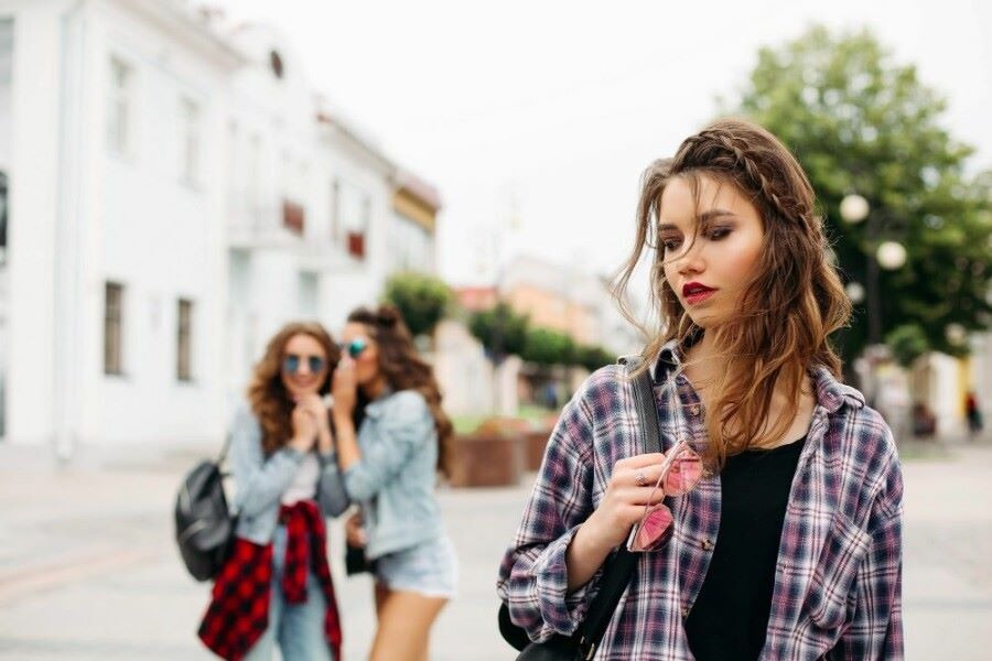 jealous girls whispering about third girl