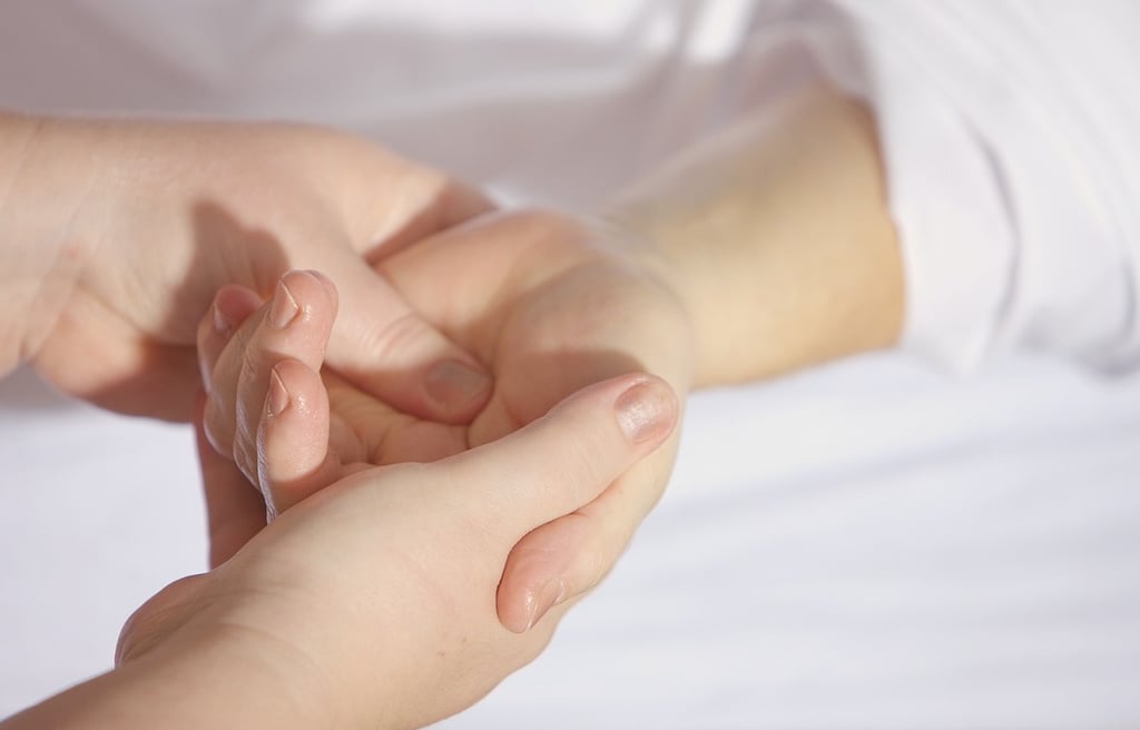 Therapist holding hand of a patient and giving a massage.