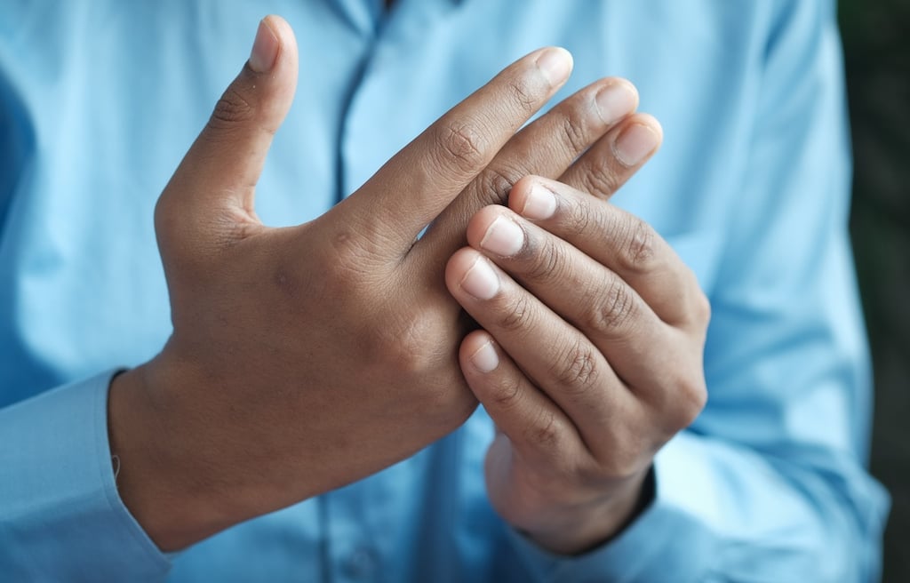 Man holding his hands, because of his arthritic pain.