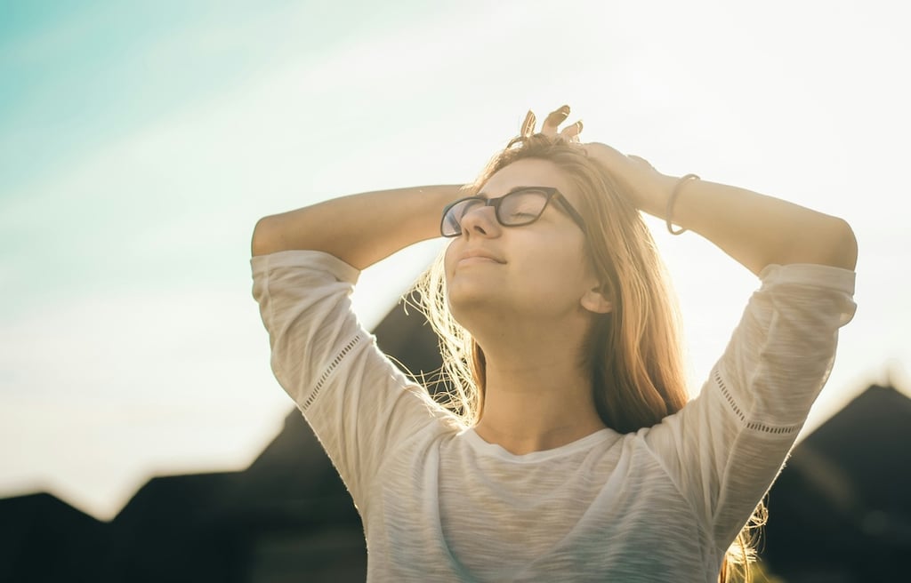 Young woman with hands behind her head, feeling relief from her pain.