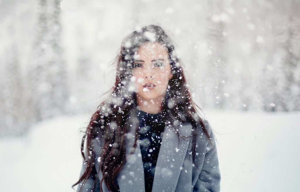 Young woman in the snow, appearing in pain.