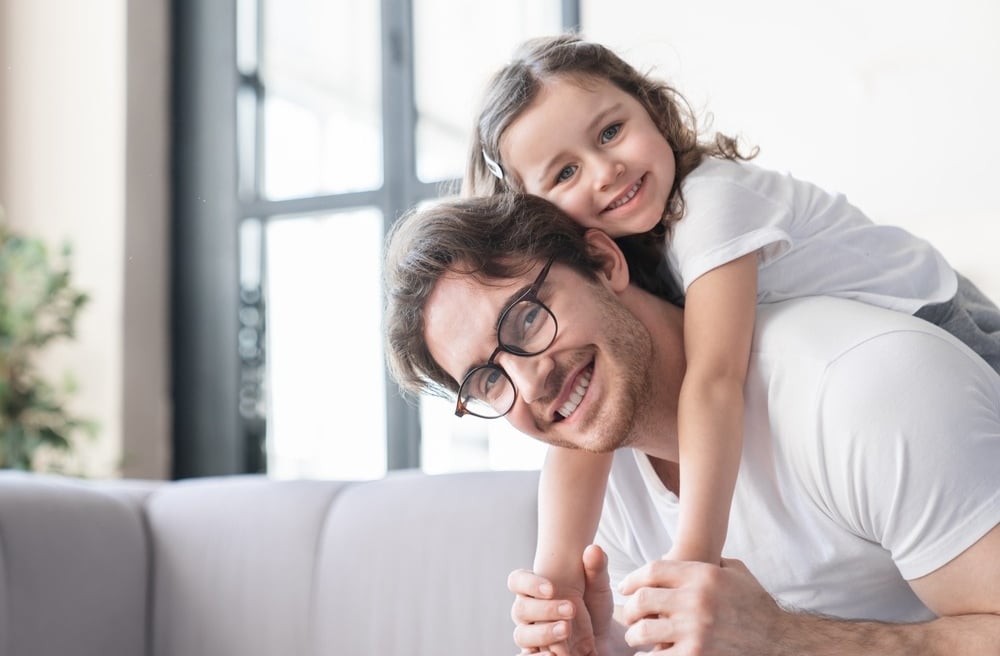 A man and a little girl are smiling and having fun