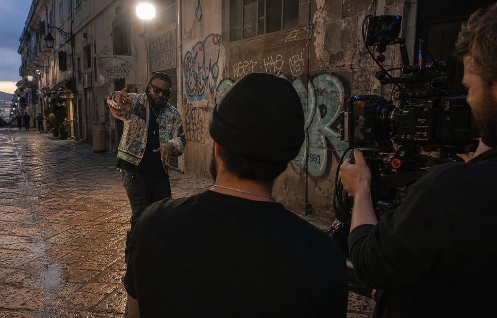 Produção de videoclipe profissional com equipa filmando artista em cenário urbano