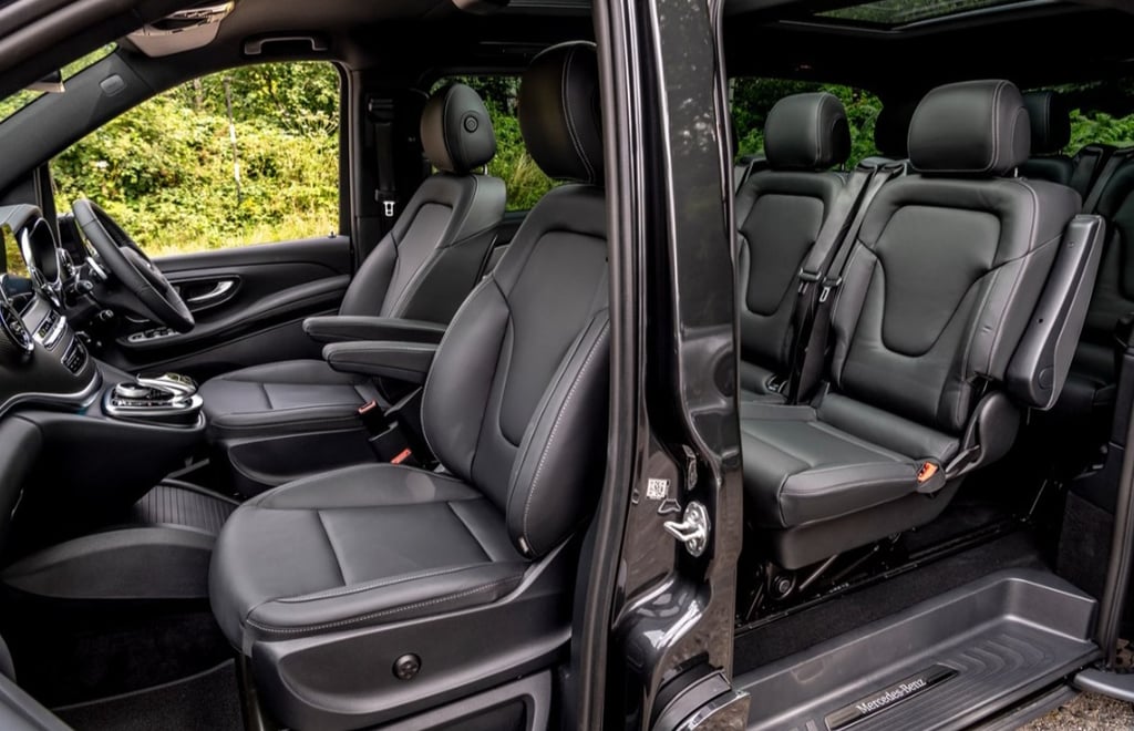 Luxury black leather seats inside a spacious Mercedes-Benz passenger van with modern interior design.