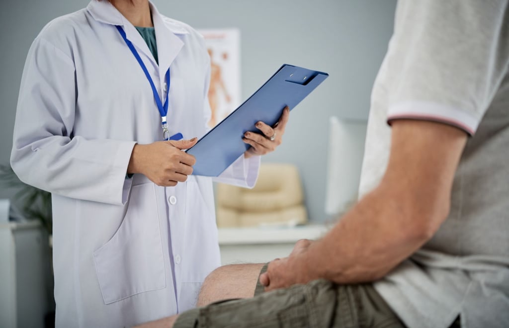 a doctor holding a clipboard and talking to the patient