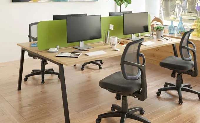 a desk with two computer monitors and a desk with two chairs