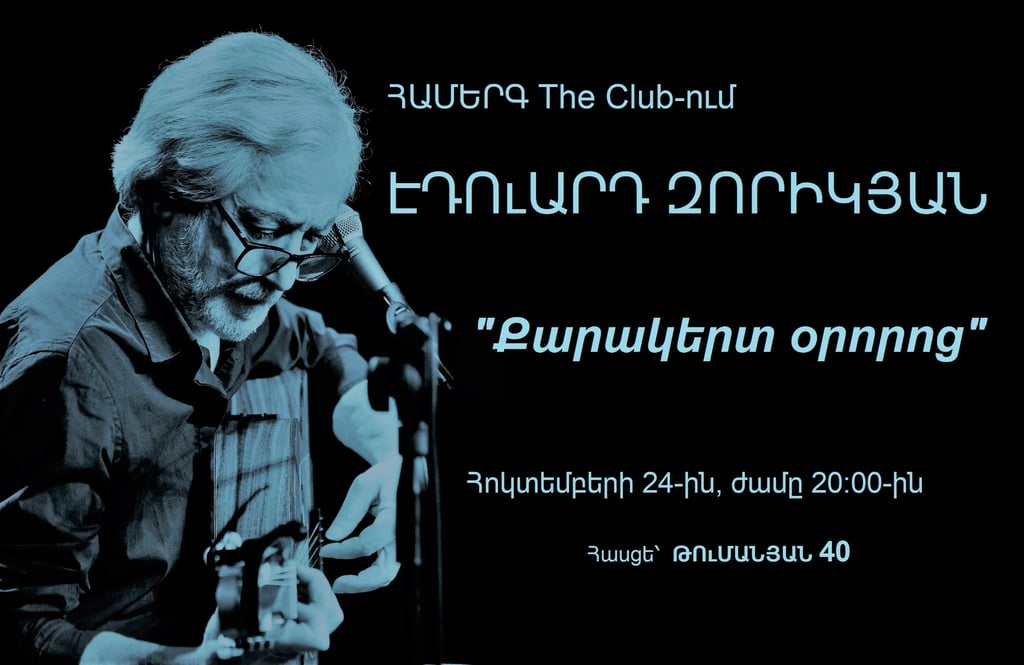 Eduard Zorikyan performing live concert at The Club with acoustic guitar and blue filter.