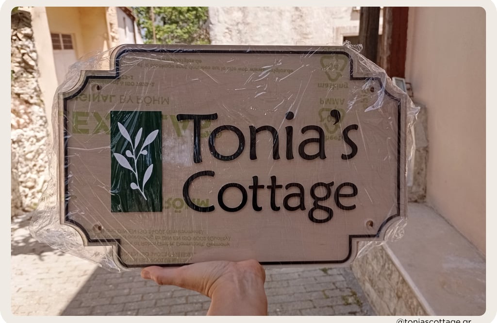 Tonia's Cottage holiday rental logo in Crete, Greece, held in hands before placing on the wall
