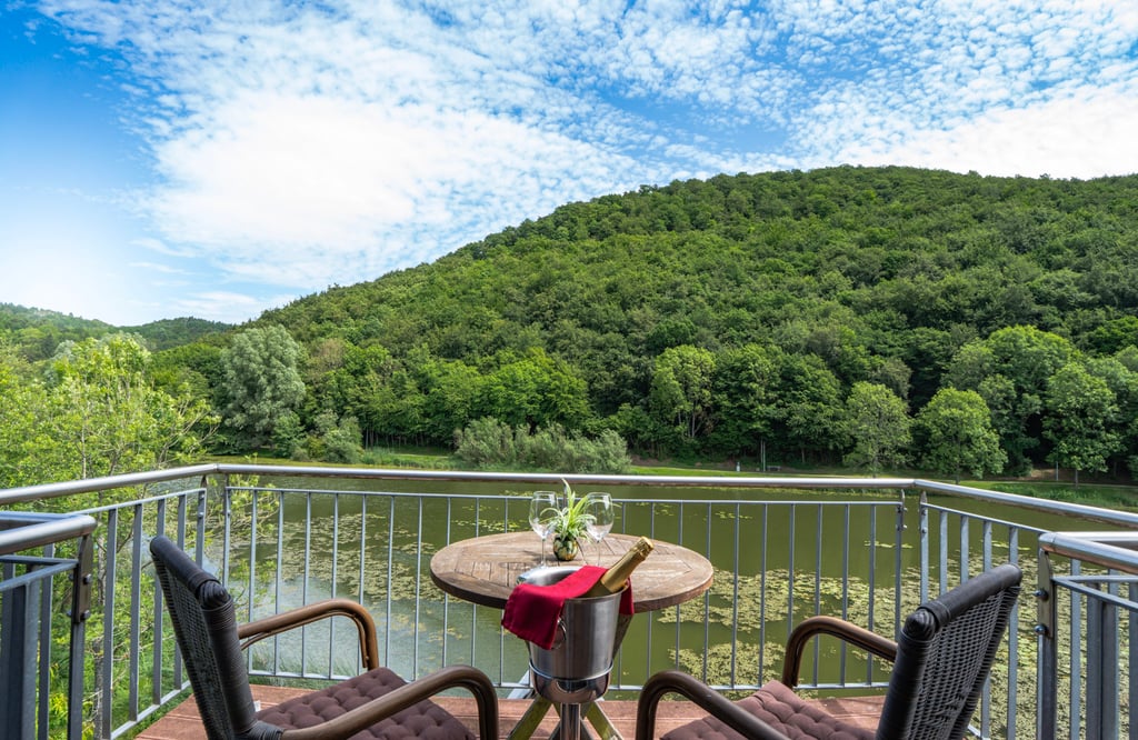 Balkon eines Hotels mit Blick auf den See und die umliegende Natur, professionell fotografiert.