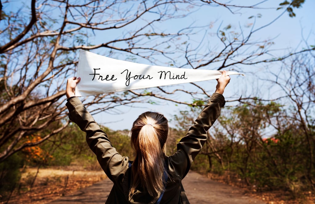a woman holding a banner that says free your mind