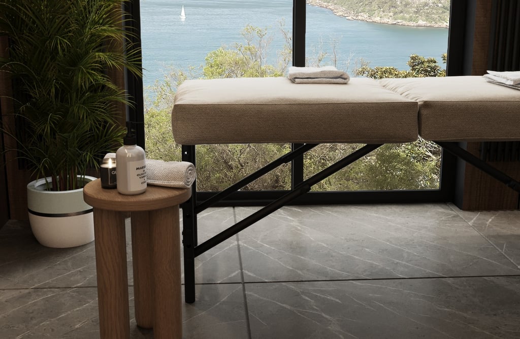 a massage table with towels and side table with candle