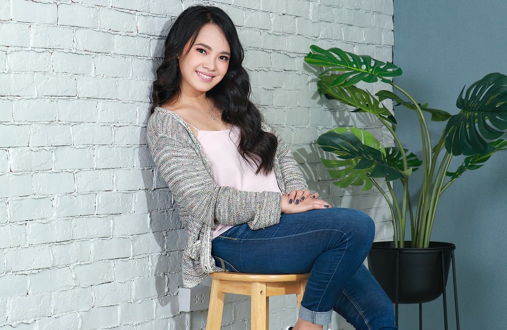 Lian sitting on a stool in a room.