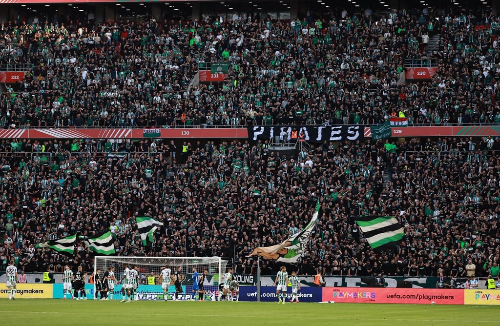 Ferencvárosi TC-Fans im Stadion der Groupama Aréna, jubelnd mit Vereinsfarben und Fahnen, während sie ihre Mannschaft lautsta