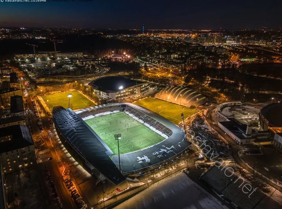 Luftaufnahme der Bolt Arena in Helsinki, einem modernen Fußballstadion mit umlaufenden Tribünen, umgeben von Wohnhäusern und