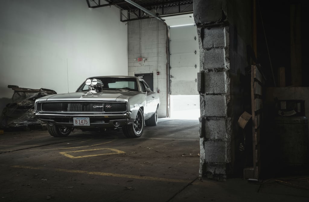 Vintage silver 1968 Dodge Charger R/T muscle car with a supercharged engine in a garage.