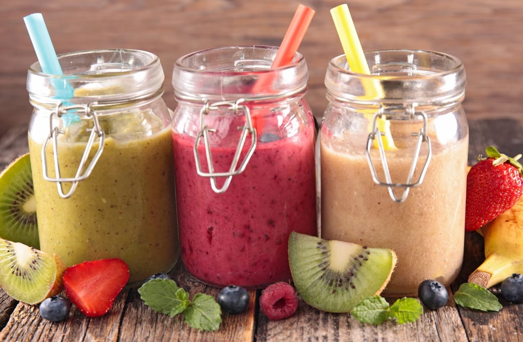 three jars of fruit smoothies with fruit and strawberries