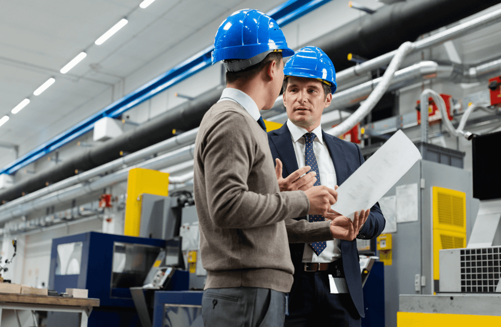 Engineers discussing plans on a factory floor