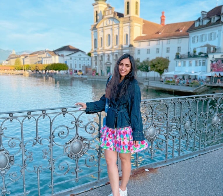 a woman standing on a bridge over looking at the water