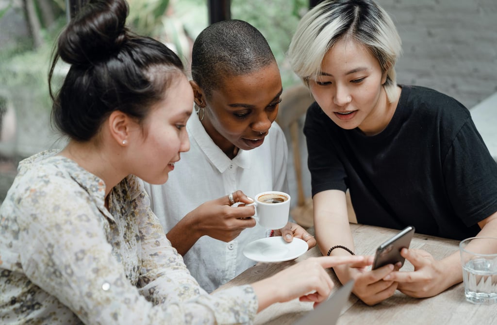 3 young women looking at phone