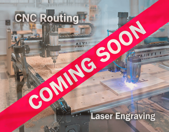 Industrial CNC routing and laser engraving machines in a workshop with a coming soon banner.