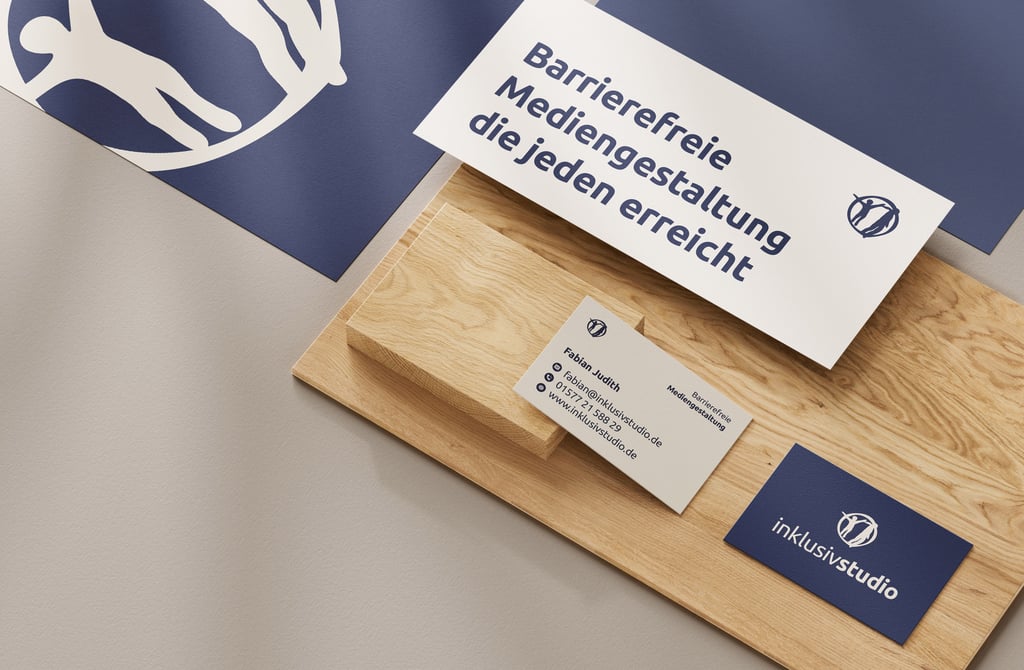 Zwei Visitenkarten, ein Flyer und Briefpapier auf Holzplatte