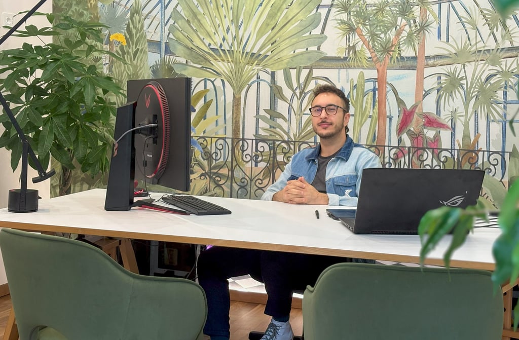 the owner sitting at the desk of the studio with his computer