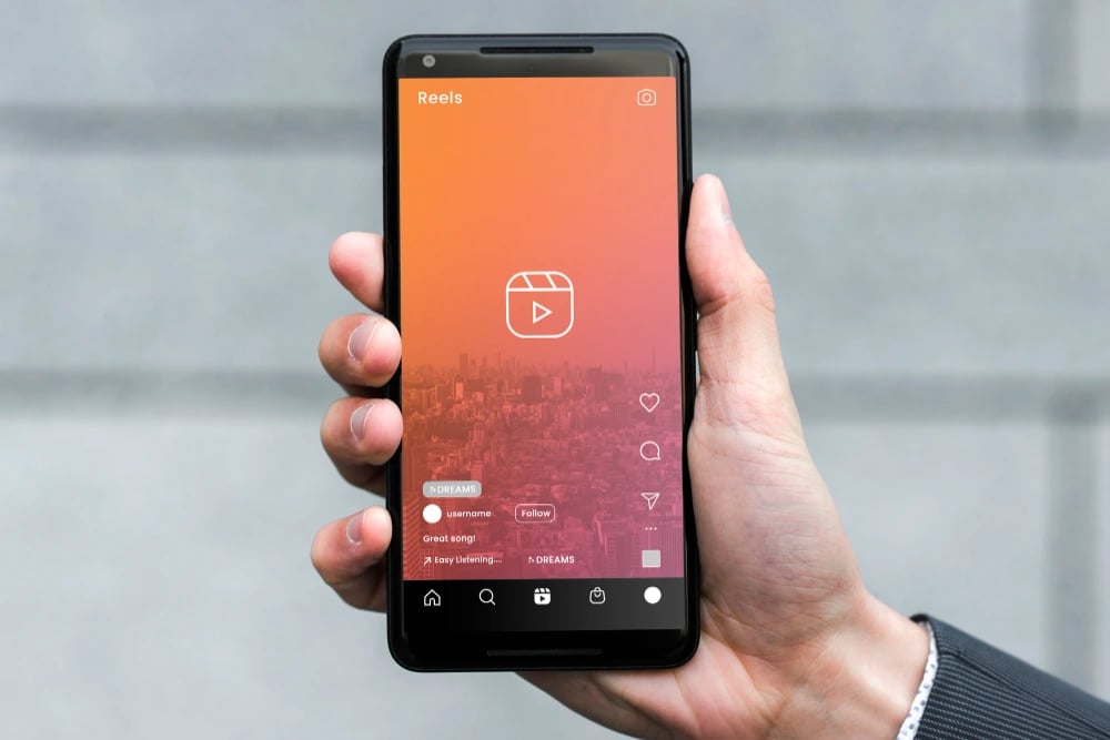 Homem de terno segurando o celular com o Instagram aberto