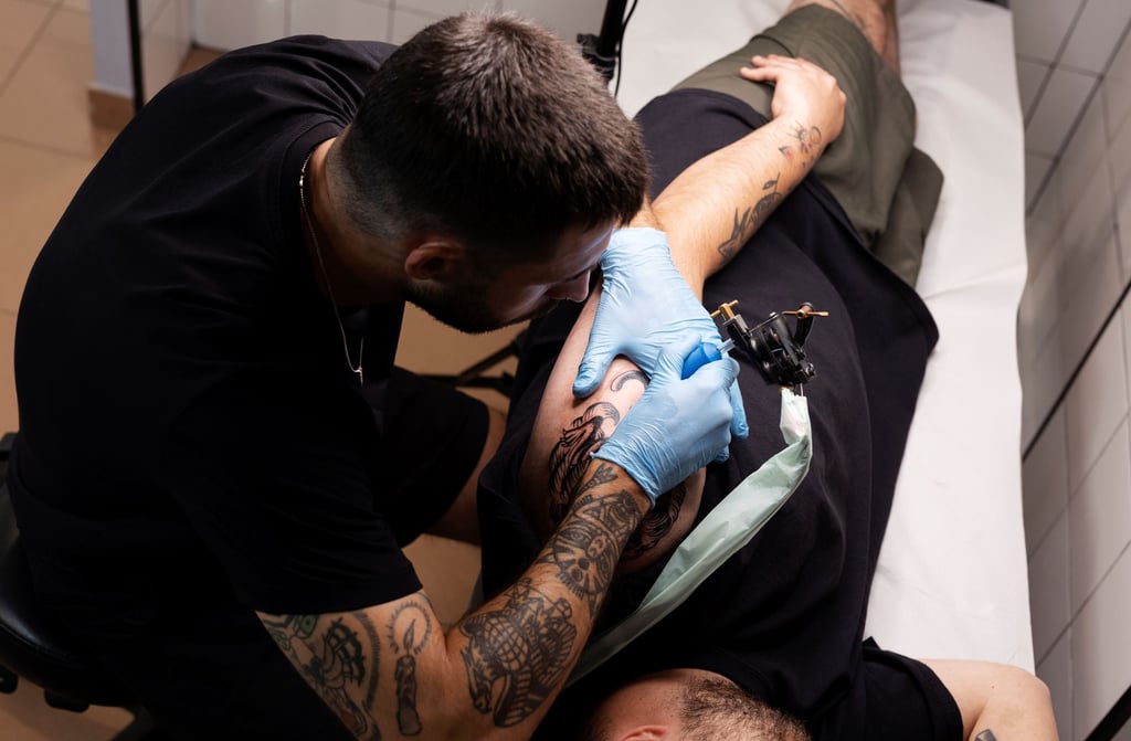 a man getting a tattoo on his arm