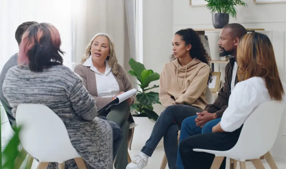 Multiple staff sitting in a mental wellness meeting