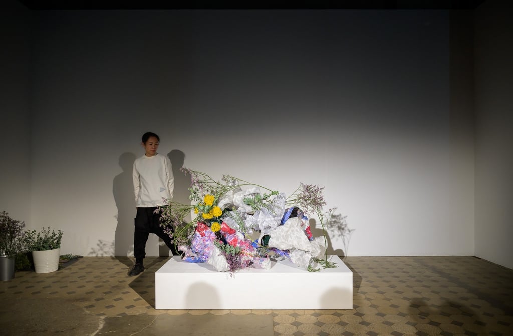 Hedy Leung interacting with the hand-built vessels and green materials during opening performance