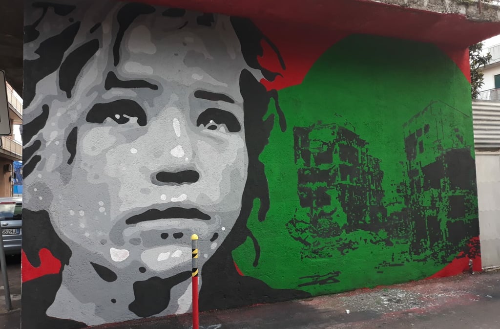 Social-themed mural with female face and ruined buildings, urban art by Poliops.