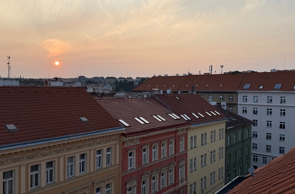 a sunset over a cityscapeople of buildings
