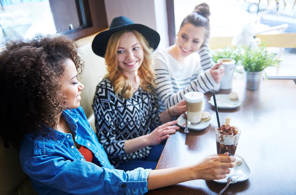 three women sitting at a table with drinks