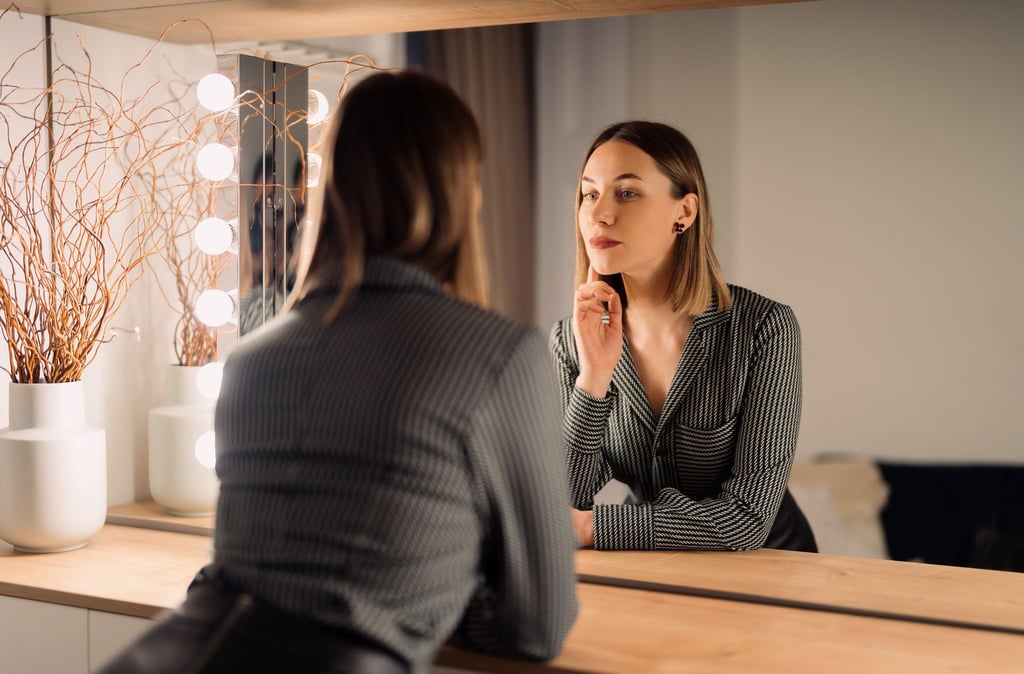 a woman in a business suit is looking at her reflection in the mirror
