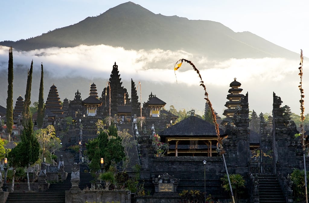 Besakih Temple gates made of black volcanic stone against a clear blue sky