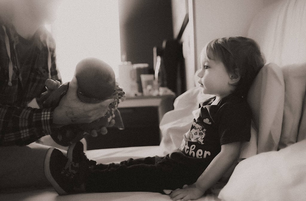 Big Brother getting ready to hold baby brother for the first time