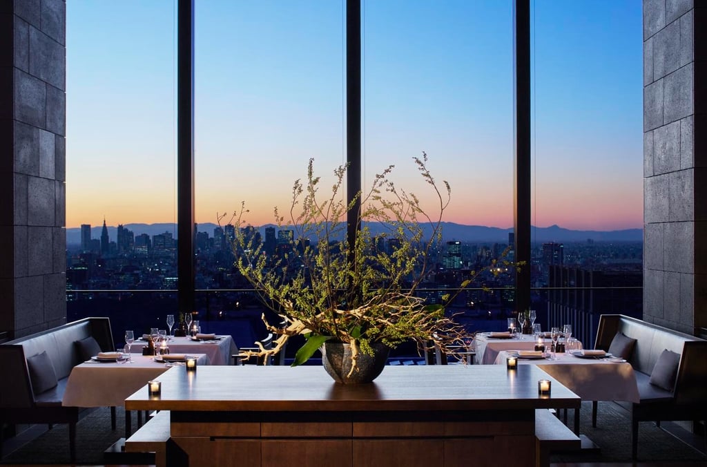Aman Tokyo Elegant restaurant Avra with city view at sunset.