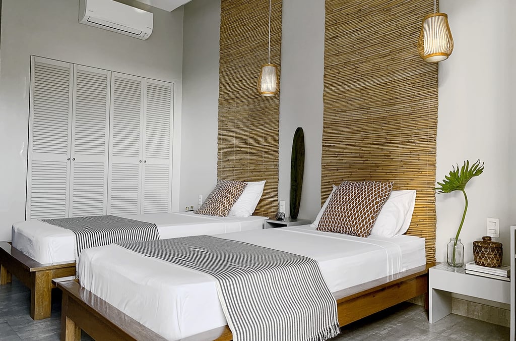 a bedroom with two beds and a surfboard